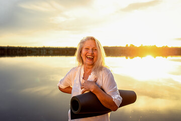 Portrait of senior woman with yoga mats.