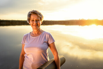 Fototapeta na wymiar Portrait of senior woman with yoga mats.