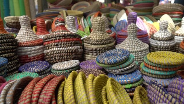 Handmade colorful straw containers and pots selling on the market as a decorative baskets. Decorative accessories for storage or carrying.