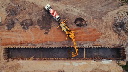 Lorry crane and a truck concrete mixer. Open-cut trench excavation and underground utility construction in Warsaw, Poland. Drone top view. High quality photo