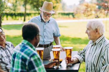 Fototapeta na wymiar Group of senior friends drinking a beer at the park