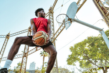 One vs one basketball game training at the court. Cinematic look image of friends practicing shots and slam dunks in an urban area © oneinchpunch