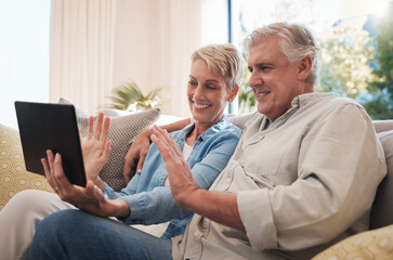 Senior couple digital tablet, wave and video call with a talking on the sofa in the living room. Video conference with elderly man and woman smile, happy and conversation online with virtual chat