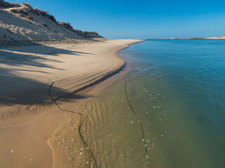 View of Praia das Furnas golden sand beach with turquoise water of the Mira river at Vila Nova de Milfontes, Vicentine Coast Natural Park Portugal. Sunny day , blue sky
