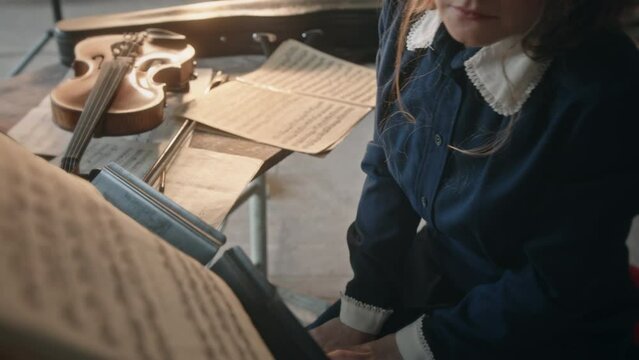 Crop female musician preparing sheet music