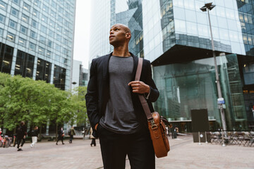 Young business man going to work in the morning passing by an urban area of the city. Representation of a successful sales person reaching the top of the career.