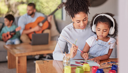 Creative family, mom and girl doing art and craft with dad and in background with guitar in home....