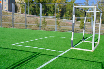 Football field with gate and freshly laid green lawn.