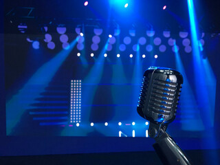 Singer microphone on stage in blue lights, performing live on scene in music hall