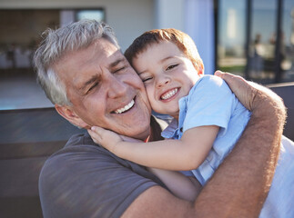 Fototapeta premium Happy, smile and grandfather hugging his grandchild while playing together at the family home. Happiness, playful and elderly man in retirement embracing and bonding with his toddler grandson.