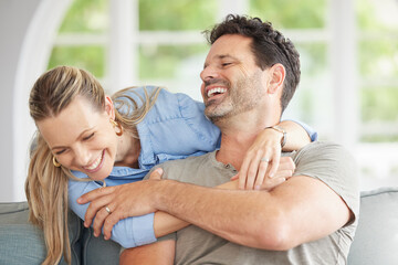 Fototapeta premium Love, relax and marriage couple hug on sofa together for sweet embrace with cheerful smile. Happy, caring and romantic people in married commitment enjoy bonding time in home living room.