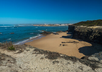Praia das Furnas sand beach with view over the Mira river to Vila Nova de Milfontes, wild Rota Vicentina Coast Natural Park Portugal.