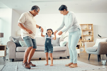 Happy grandparents, girl and dance holding hands in home living room with music having fun sharing...