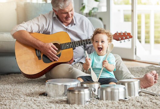 Music, pots and baby drummer with old man on living room floor with pan and wooden spoon instruments with his guitar. Memory, smile and senior grandparent enjoys time with a happy grandchild