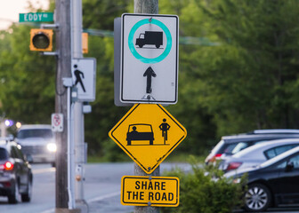 SHARE THE ROAD a road sign with a bicycle symbol informational for the traffic. Yellow Diamond Warning Sign