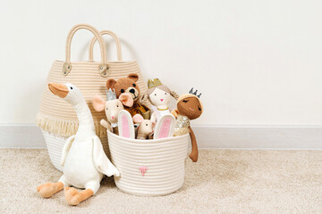 Beige Toy Storage Baskets in the children's room. Cloth stylish Baskets with  toys and rag dolls. Organizing and Storage Ideas in nursery. Clean up toys and reduce the clutter. House cleaning. - obrazy, fototapety, plakaty