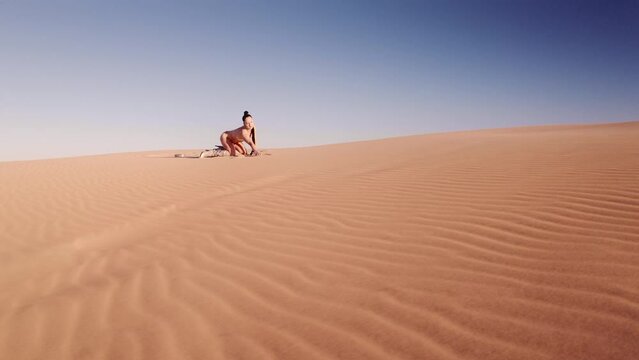 Drone Of Woman In Bikini Stretching On All Fours In Desert