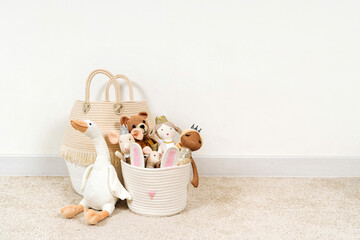 Fototapeta na wymiar Beige Toy Storage Baskets in the children's room. Cloth stylish Baskets with toys and rag dolls. Organizing and Storage Ideas in nursery. Clean up toys and reduce the clutter. House cleaning.
