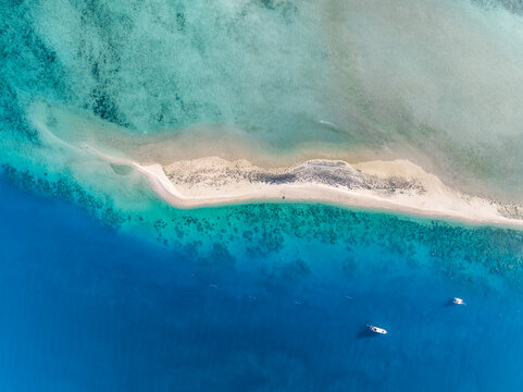 High angle aerial drone view of Langford Island's sandspit or sandbar, a small islet near Hayman Island in the Whitsunday Islands group near the Great Barrier Reef in Queensland, Australia.