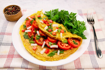 Homemade egg omelette with tomatoes and parsley on a gray background