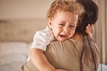 Mother and crying baby in a bedroom with portrait of sad son looking upset at nap time. Children,...