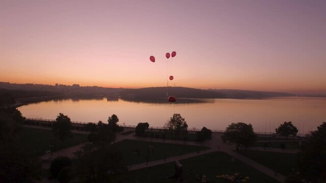 Aerial view the balloon heart flies in sky over lake beautiful sky and sunset
