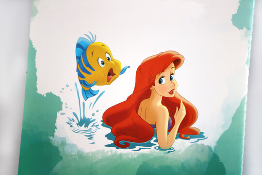 Disney princess. Ariel the Little Mermaid and Flounder. Illustrations in a magazine. Characters from classic children's stories.	