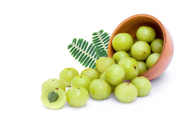 Indian gooseberry fruit or Amla (phyllanthus emblica) in wooden bowl with green leaf isolated on white background.