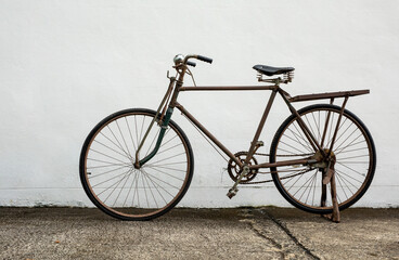 Vintage old bike standing against white wall background