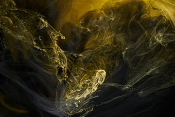 Liquid fluid art abstract background. Black, yellow dancing acrylic paints underwater, space smoke ocean