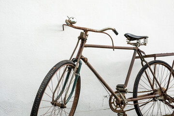 Fototapeta na wymiar vintage old bike leaning against white wall background