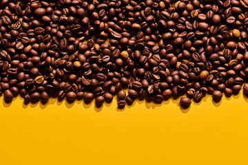 Roasted coffee beans on yellow background