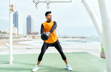 Fototapeta premium Young athlete training in the morning on the beach at the gym. outdoor. Representation of sport and healthy lifestyle concepts