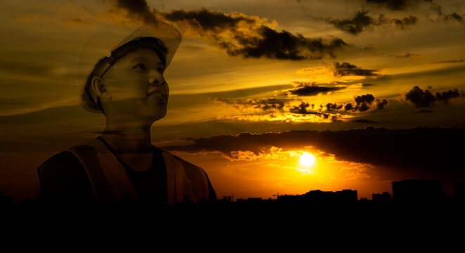 Silhouette double exposure image of architecture or civil engineer with orange sky sunset,builder wearing helmet,construction industry expand and grow,concept work in success.