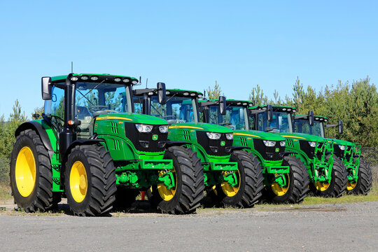 Line Up of New John Deere 6155R Tractors on a Yard