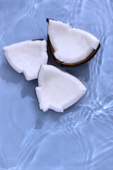 Fototapeta na wymiar Coconut cracked in water under palm shadow