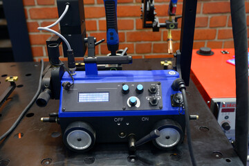 Automatic portable welding tractor carriage for carrying welding torch, placed on stand. Kyiv,...