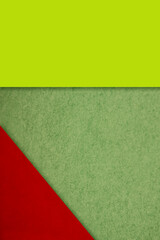Textured and plain yellow green red sheet papers forming two triangles and vertical blank rectangle for creative cover designing