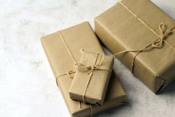Gift boxes wrapped in brown recycled paper on the table, new year gifts, birthday gifts, brown...