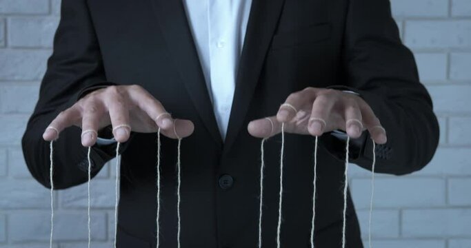 Influence with fingers. A man with influence hold in his hands the strings from his employees.