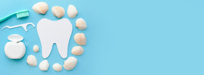 Fototapeta na wymiar Banner with tooth model, toothbrush, dental floss and seashells. Blue background. Flat lay. Top view. Benefits of minerals for dental hygiene. Oral care. Place for text. Copy space.