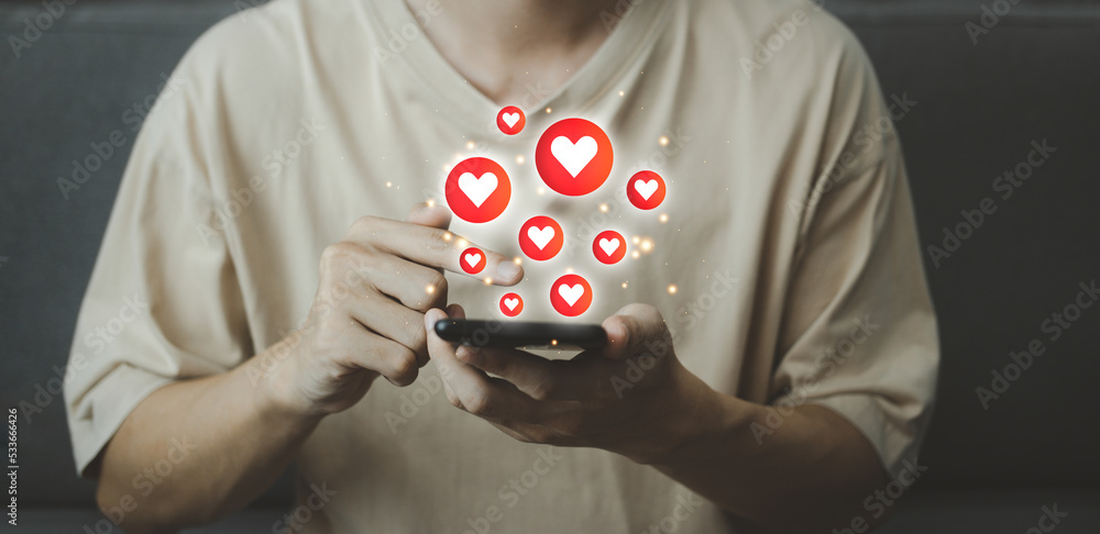 Poster chat and notification on smartphone with virtual red heart emoji social media icon. man using smartp