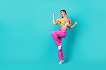 Fototapeta na wymiar Full size photo of yell young lady yell hands fists wear floral top pink pants shoes isolated on teal color background
