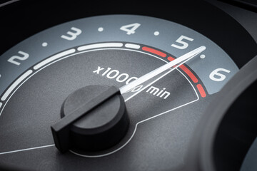 Close up of the tachometer pointer in red zone of gauge