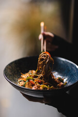 Noodles with seafood and vegetables on a dark background. Asian food.