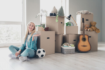 Photo of charming sweet young girl wear jeans shirt relocating new apartment packing boxes indoors house room