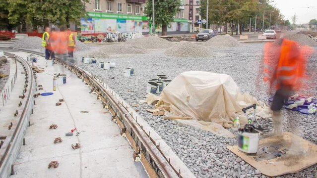 Workers install new tram rails on concrete plates during a reconstruction of the route timelapse. Filling by liquid resin for reduction of vibration and noice. Modernizations of tram tracks