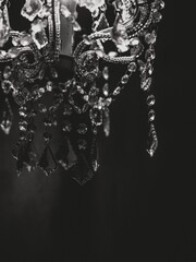 Vertical greyscale shot of the details of a gorgeous chandelier