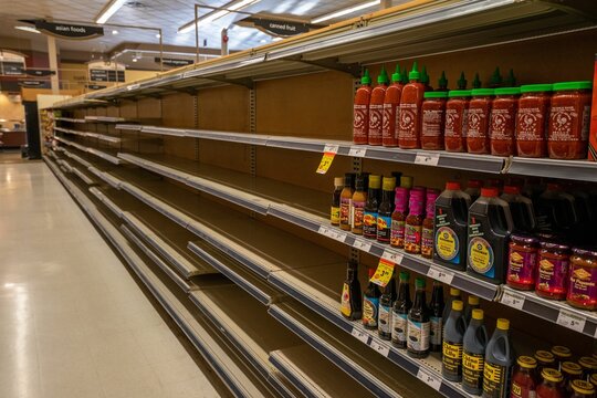 Empty grocery store shelves with many products missing.