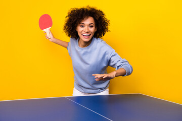 Portrait of positive cheerful person hold ping pong racket playing tennis isolated on yellow color...